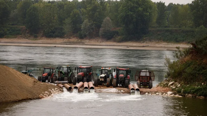 Traktory nabírají vodu z řeky