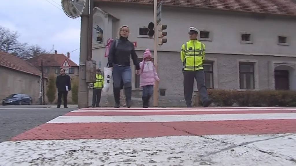 Policisté pomáhají dětem přecházet silnici