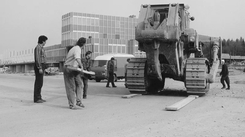 Výstavba nového Masarykova okruhu v letech 1985 - 1987.Buldozer přejíždí přes čerstvě dokončenou cílovou rovinku Masarykova okruhu. V pozadí řídící věž.