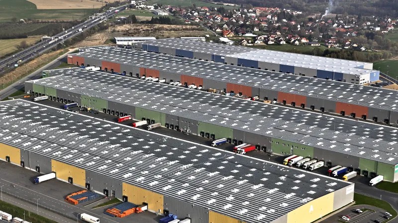 Logistická centra na 16. km D1. Za nimi obec Kunice