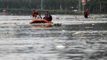 Záchranáři evakuují ohrožené obyvatele pomocí člunu
