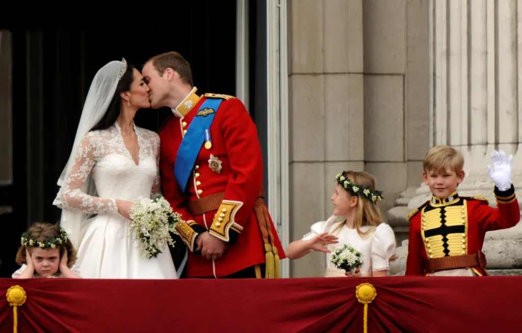 Mezi šťastnější momenty uplynulé dekády patří svatba britského prince Williama a Catherine Middletonové. Na snímku jsou zachyceni na balkoně Buckinghamského paláce. Ne všichni však vypadali nadšeni - děvče vlevo je družička Grace van Cutsemová, kterou „královský“ polibek vůbec nezaujal. Foto z 29. dubna 2011
