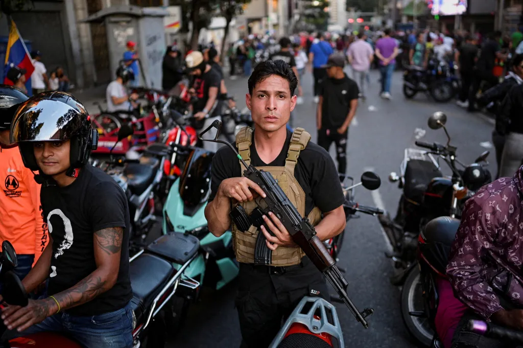 Člen provládních ozbrojených gangů colectivos se účastní pochodu požadujícího propuštění prezidenta Nicoláse Madury a jeho ženy Cilie Floresové