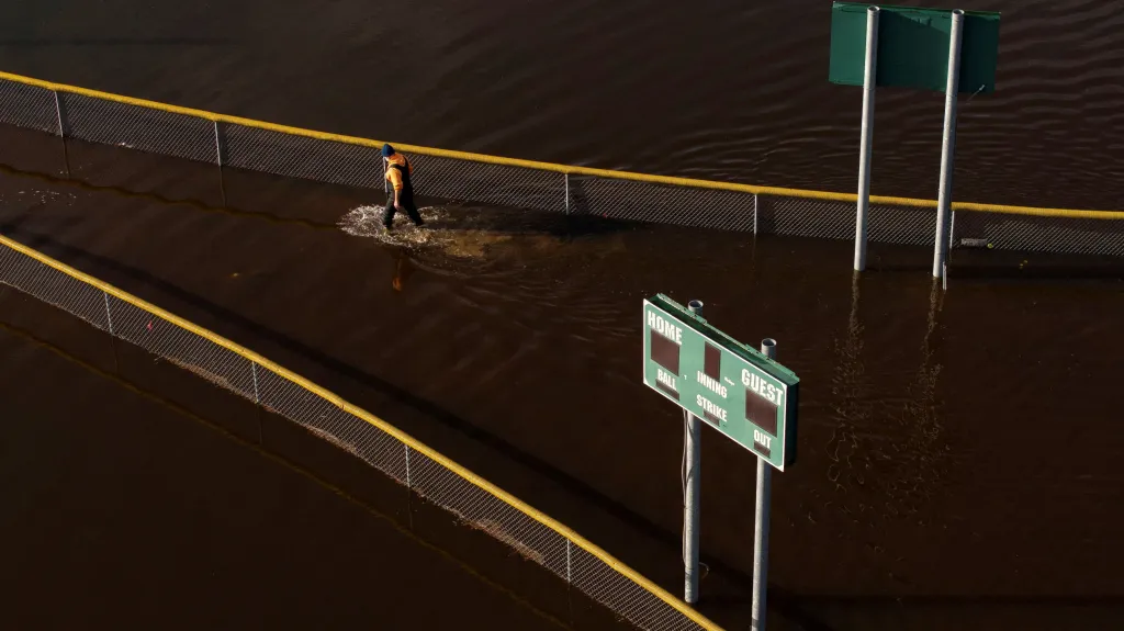Muž se brodí mezi baseballovými hřišti, která zaplavila řeka Snoqualmie