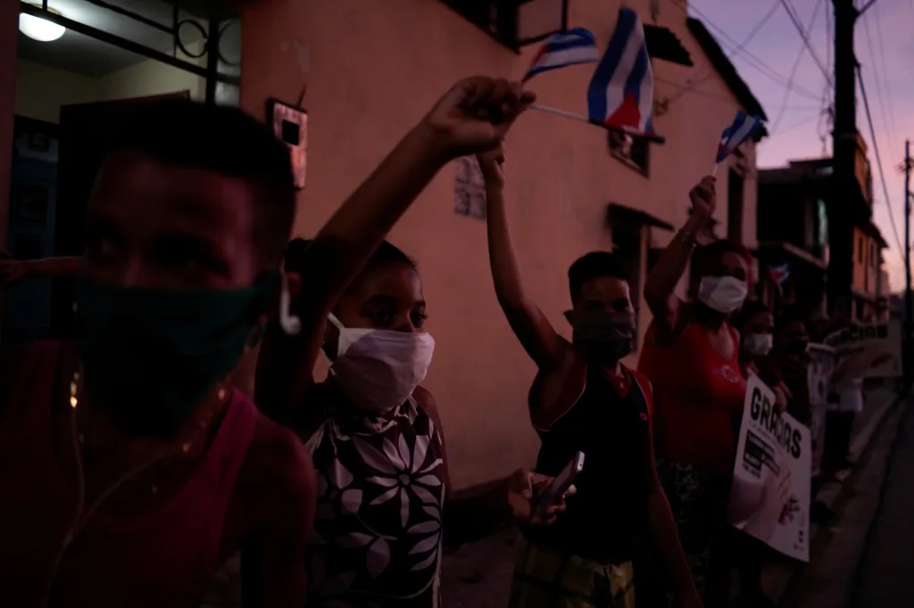 Místní obyvatelé vítají zdravotníky po jejich návratu z Itálie