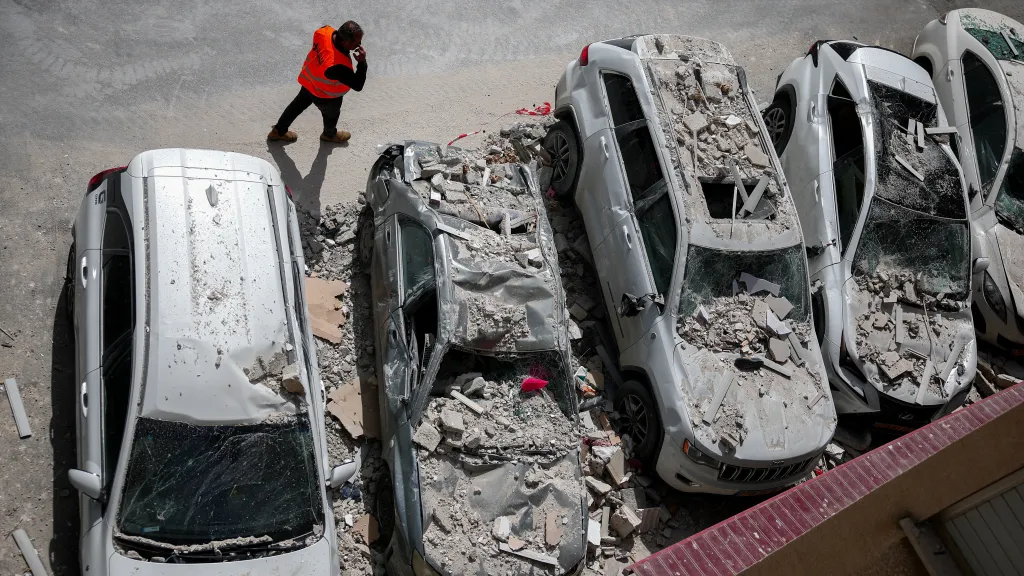 Auta poškozená po zásahu budovy ve středním Izraeli íránskou raketou