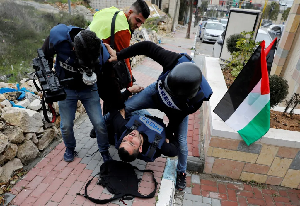 Zraněný palestinský fotožurnalista je evakuován ve městě Hebron během protestů proti Izraeli