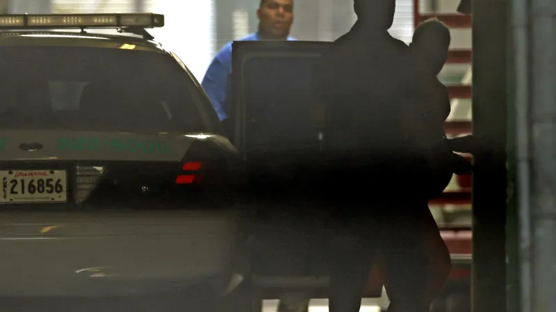 Robert Durst (vpravo) je eskortován policií k soudu v New Orleans