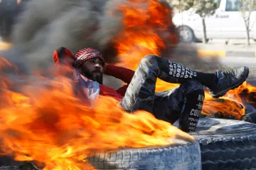 Týden obrazem: Polonahá armáda, robot dirigentem a muž v ohni 