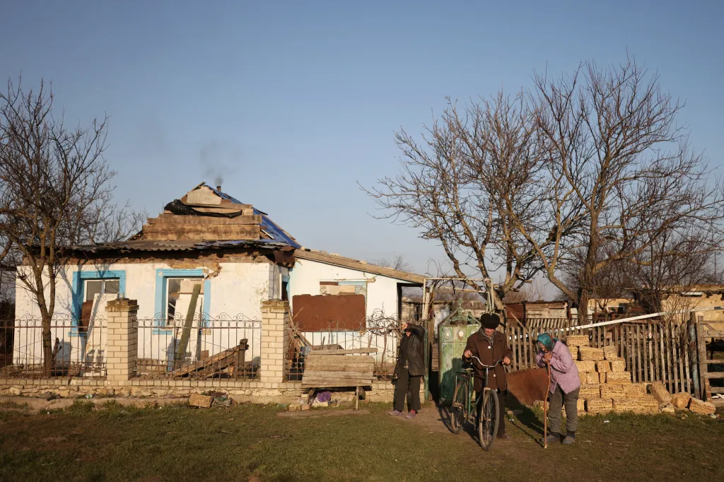 Volodymyr, Taťána a jejich vnučka Světlana stojí před plotem svého domova