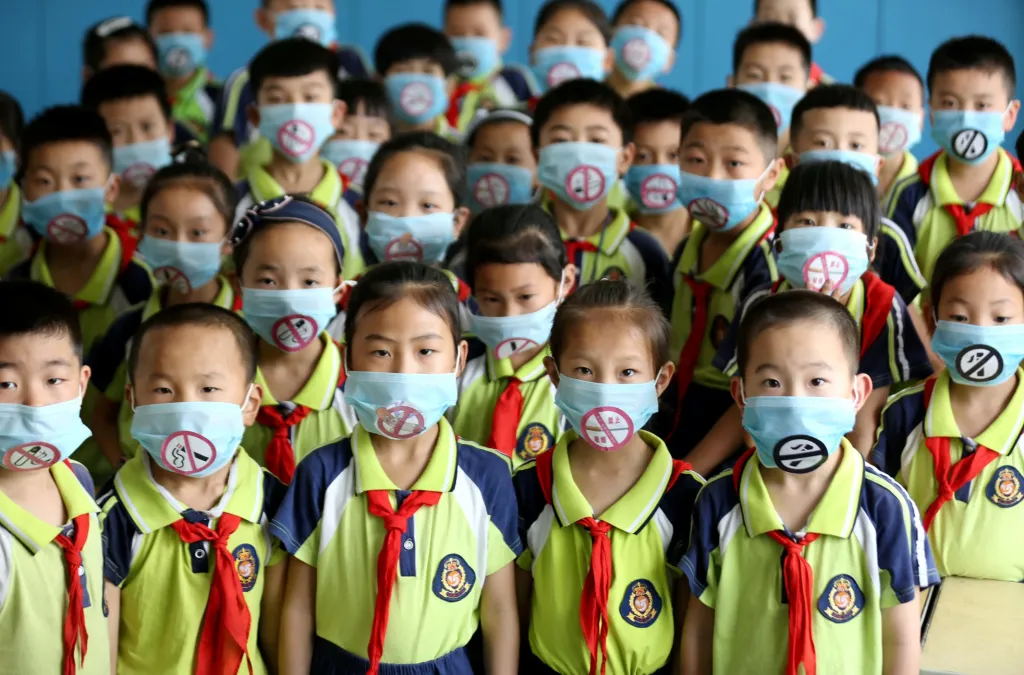 Studenti základní školy v Linyi mají masky s nápisem „Zákaz kouření“ během akce  Světového dne bez tabáku v provincii Šan-tung v Číně