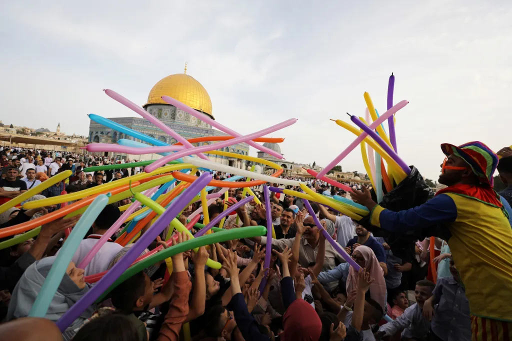 Klauni a performeři rozdávají dětem tvarovací balónky v Jeruzalémě.