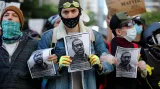 Demonstranti drží letáky zobrazující George Floyda během pochodu proti policejní brutalitě v Seattlu v USA