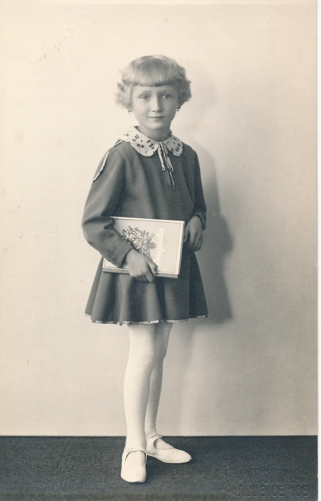 Žákyně první třídy s oblíbeným slabikářem Poupata, 1931, soukromá sbírka.