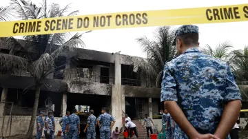 Příslušníci bangladéšského letectva na místě, kde se cvičný letoun zřítil (22. července 2025)