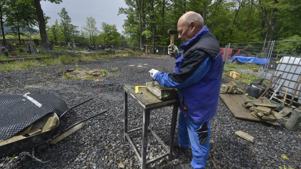 Kameník skládá kameny do nadzemních základů kostela