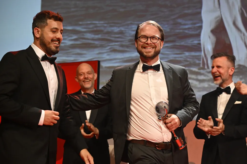 Dánský režisér Mads Mengel s cenou za nejlepší režii filmu Nečekaný host. V tomto dramatu se na oslavě novopečených rodičů nečekaně objeví matka jednoho z nich, s níž mladý pár není už několik let v kontaktu. Mengel ve svém debutu vypráví komorní příběh o rodině na hranici rozpadu a činí tak v tradici současné severské kinematografie