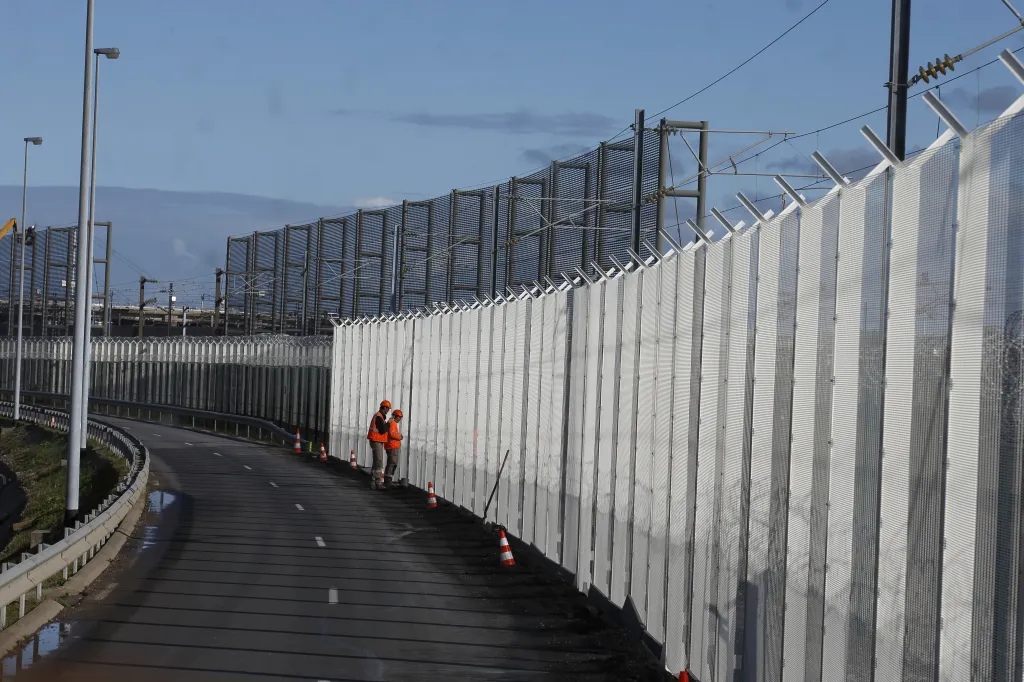 Dělníci staví nový plot, aby zabránili migrantům v přístupu k terminálu Eurotunelu v Coquelles u Calais na severu Francie (20. října 2015)
