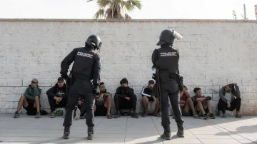 Španělští policisté s migranty v Ceutě