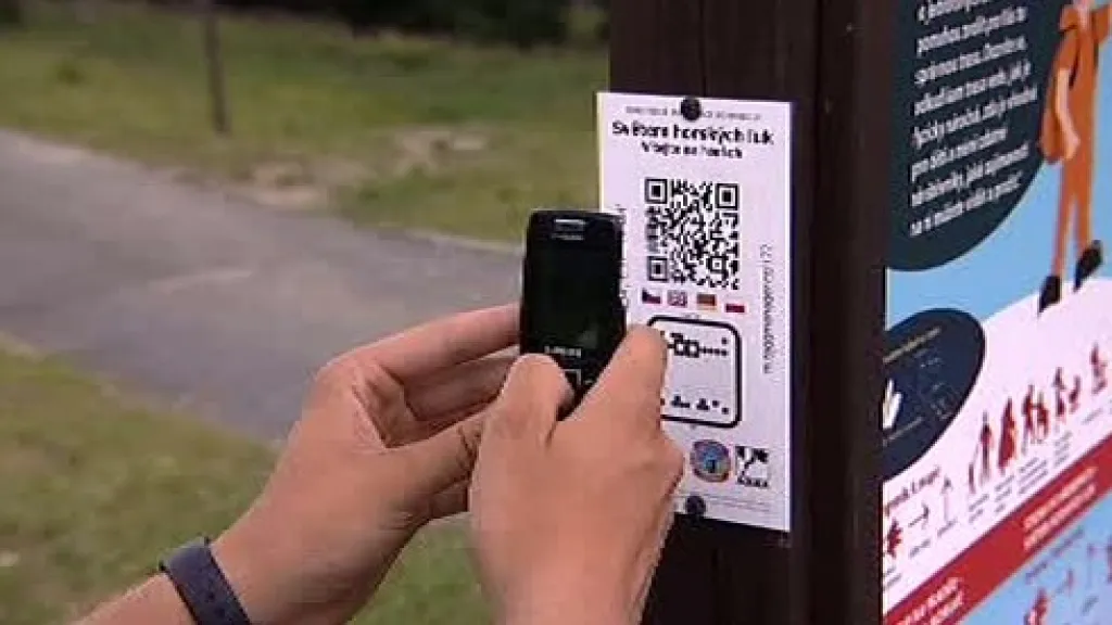 Turista fotografuje kód informační tabulky