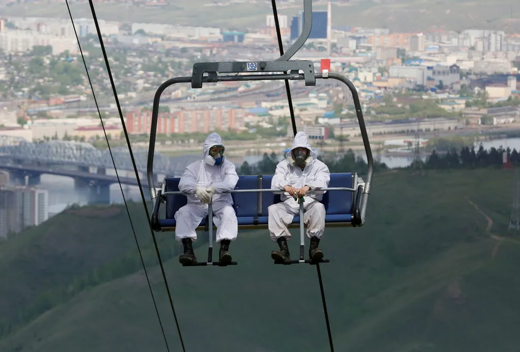 Zaměstnanci firmy na výrobu pesticidů využívají lyžařskou sedačkovou lanovku k výstupu na kopec, kde provádějí hubení klíšťat přenášejících encefalitidu v oblasti rekreačního resortu Bobrovy Log poblíž sibiřského města Krasnojarsk.