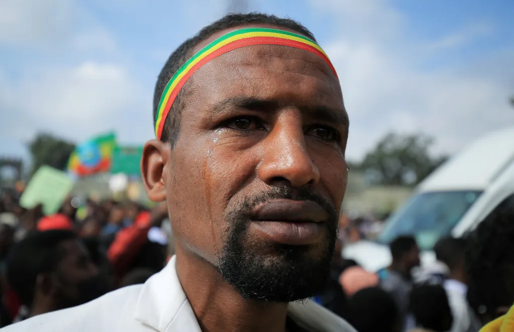 Muž stojí na shromáždění podporujícím etiopská vládní vojska a odsuzujícím expanzi tigrajských rebelů do regionálních území Amhara a Afar