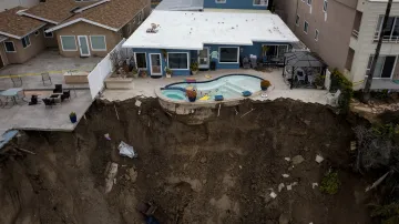 Po přívalovém dešti, který zpustošil pobřežní město San Clemente v Kalifornii, zůstal na útesu viset zahradní bazén