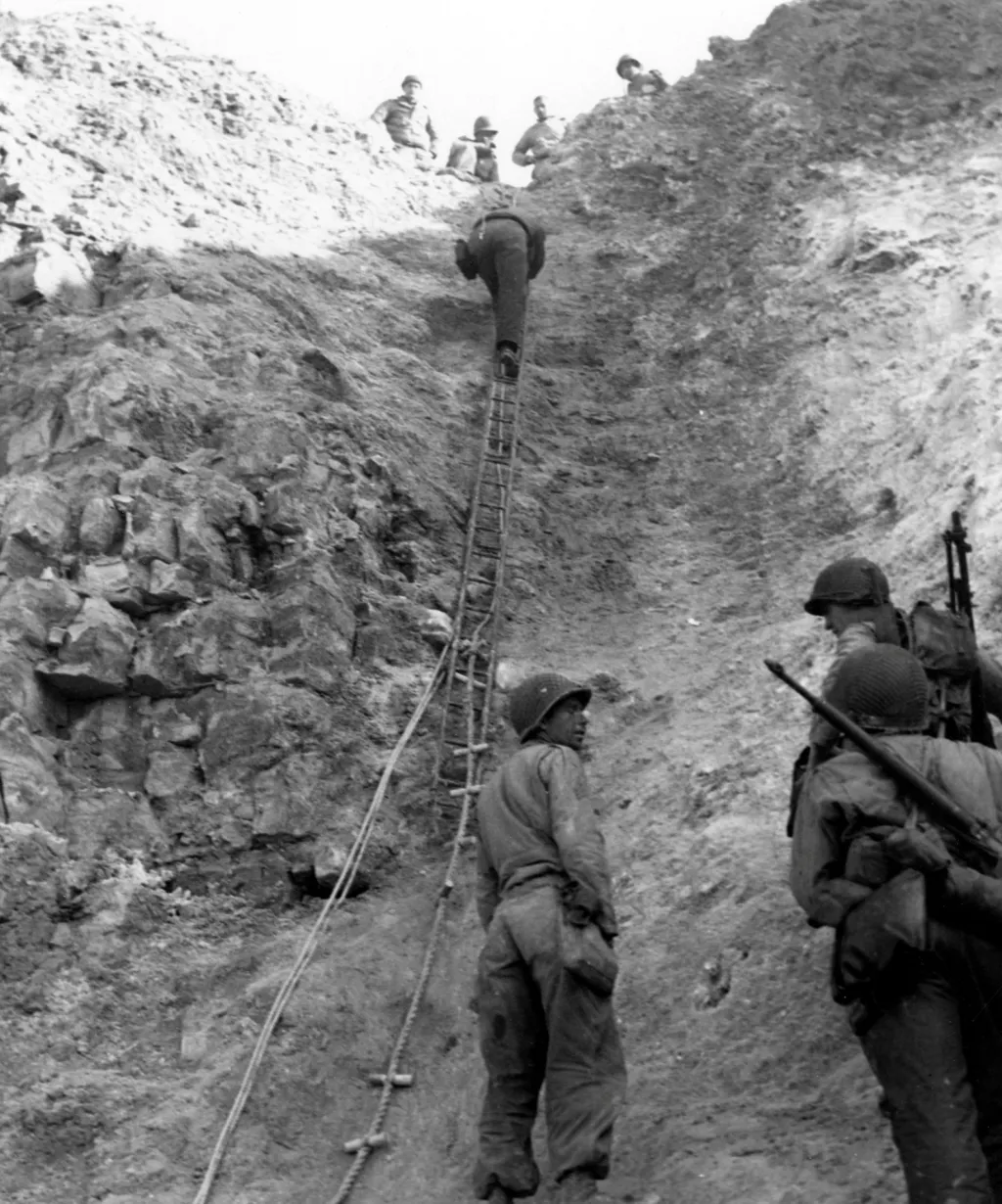 Američtí Rangers ukazují žebříky, které používali k útoku na útesy, kde napadli německou podporu během přistání na pláži Omaha
