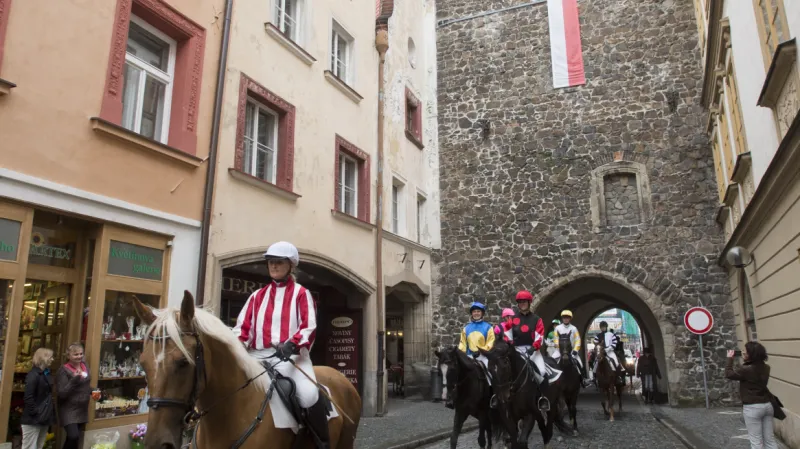 Průvod jezdců na koních projíždí Zelenou bránou