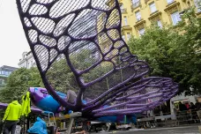 Dělníci instalují stíhačky s motýlími křídly na budovu obchodního domu Máj
