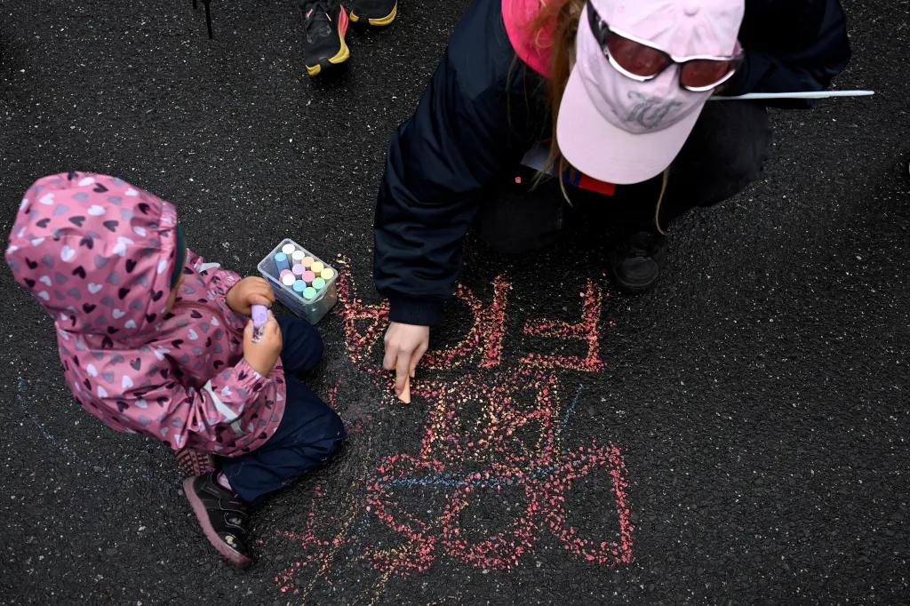Žena píše na chodník vzkaz Dost bylo Fica