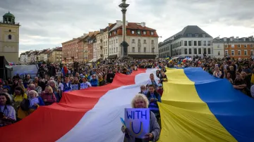 Poláci a Ukrajinci drží velké státní vlajky během shromáždění ke Dni nezávislosti Ukrajiny na Hradním náměstí ve Varšavě (24. srpna 2026)