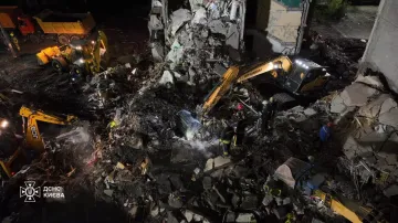 Hasiči a těžká technika v zasažené Darnycké čtvrti v Kyjevě (15. 5. 2026)