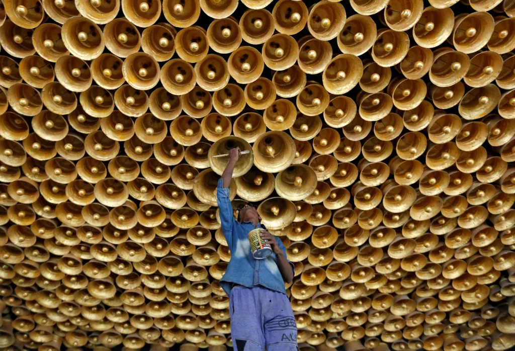 Řemeslník finálně upravuje dekorativní strop během příprav před hinduistickým festivalem Durga Puja v Kalkatě v Indii