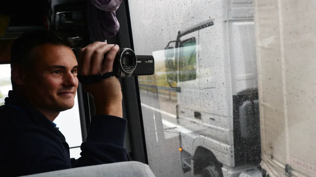 Policista kontroluje kamion z autobusu