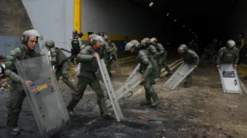 Příslušníci národní gardy Venezuely čistí uličku po protestu příznivců venezuelské opozice