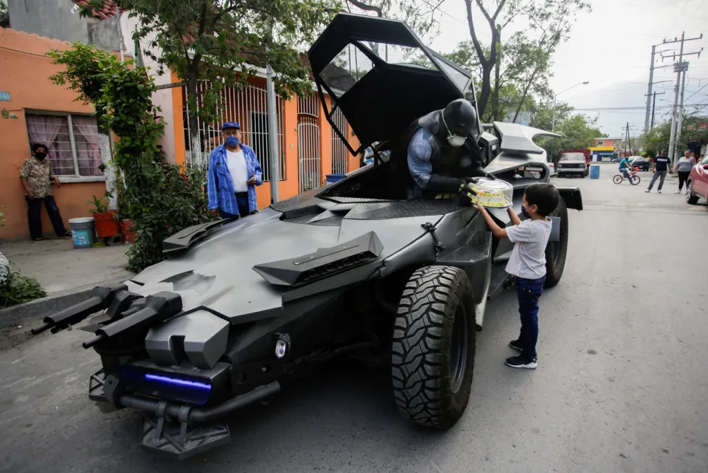 Mexický právník Candelario Maldonado, převlečený za fiktivní postavu Batmana, předává narozeninový dort dítěti na ulici před jeho domovem. Fotografie byla pořízena v Monterrey v Mexiku