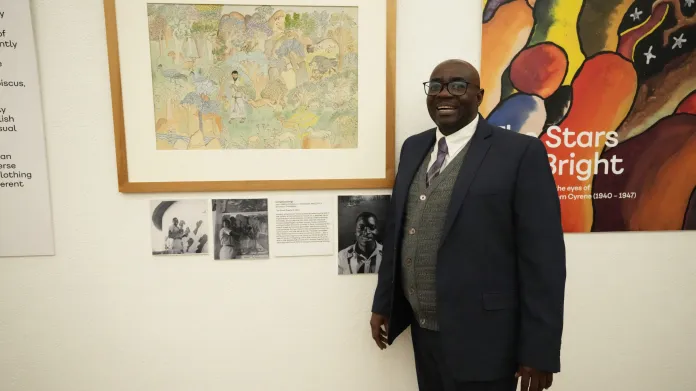 Pětašedesátiletý Livingtsone Sango stojí vedle kresby, na které jeho otec vyobrazil jako žák misijní školy Ježíše s černou barvou pleti. Fotografie (už zesnulého) otce ze 40. let, kdy práce vznikla, visí vedle obrazu