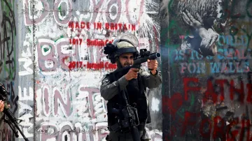 Izraelský pohraniční policista pálí slzným plynem na palestinské demonstranty v Betlémě