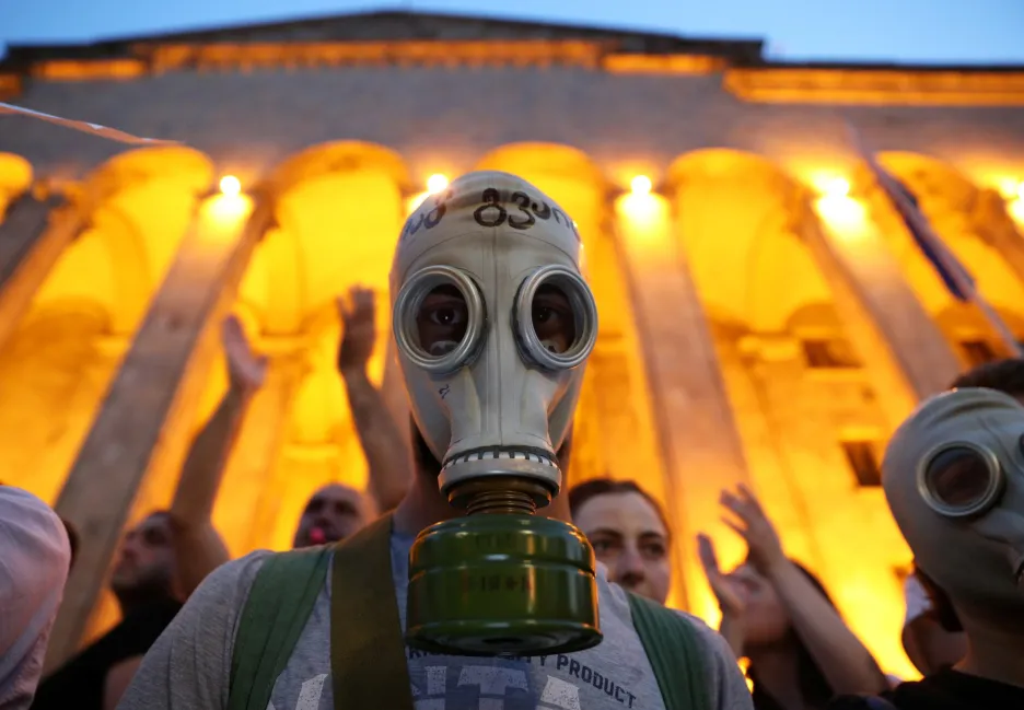 Plynové masky si nasadili protestující na shromáždění proti návštěvě ruského zákonodárce v budově parlamentu v Tbilisi.