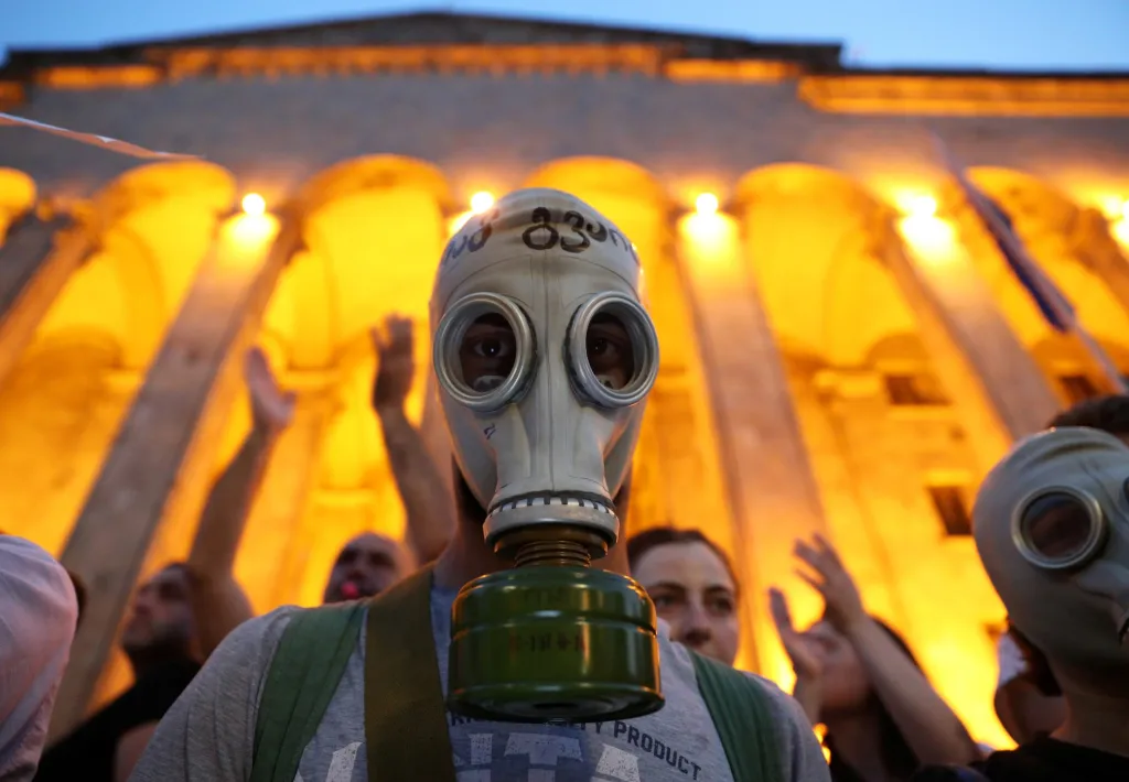 Plynové masky si nasadili protestující na shromáždění proti návštěvě ruského zákonodárce v budově parlamentu v Tbilisi.