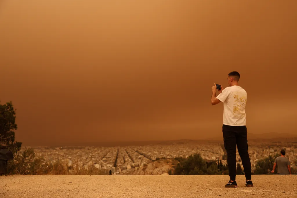Muž pořizuje fotografie Athén, které zahalil písek ze Sahary