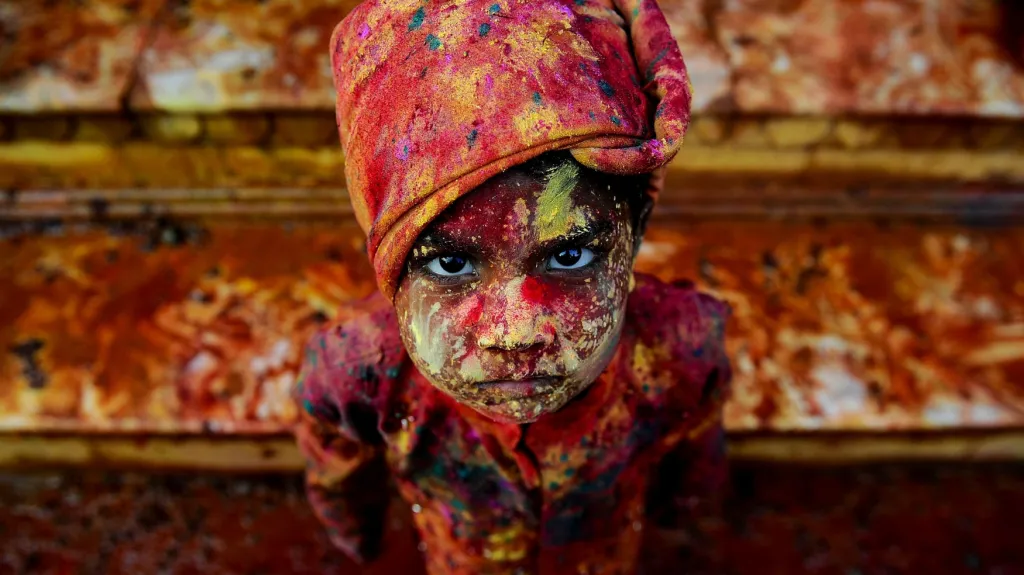Indický chlapec pomazaný barevným práškem při účasti na festivalu Holi v Mathuře. Holi, festival barev, je hýřivá oslava nadcházejícího jara a připadá každoročně na první den po po březnovém úplňku.
