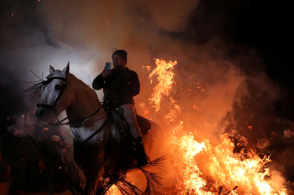 Jezdec na koni pořizuje selfie po průjezdu ohněm během tradičního festivalu ve španělské obci San Bartolome de Pinares, kde se každoročně scházejí desítky jezdců, aby své koně takzvaně očistili v ohních, které hoří po celé vesnici