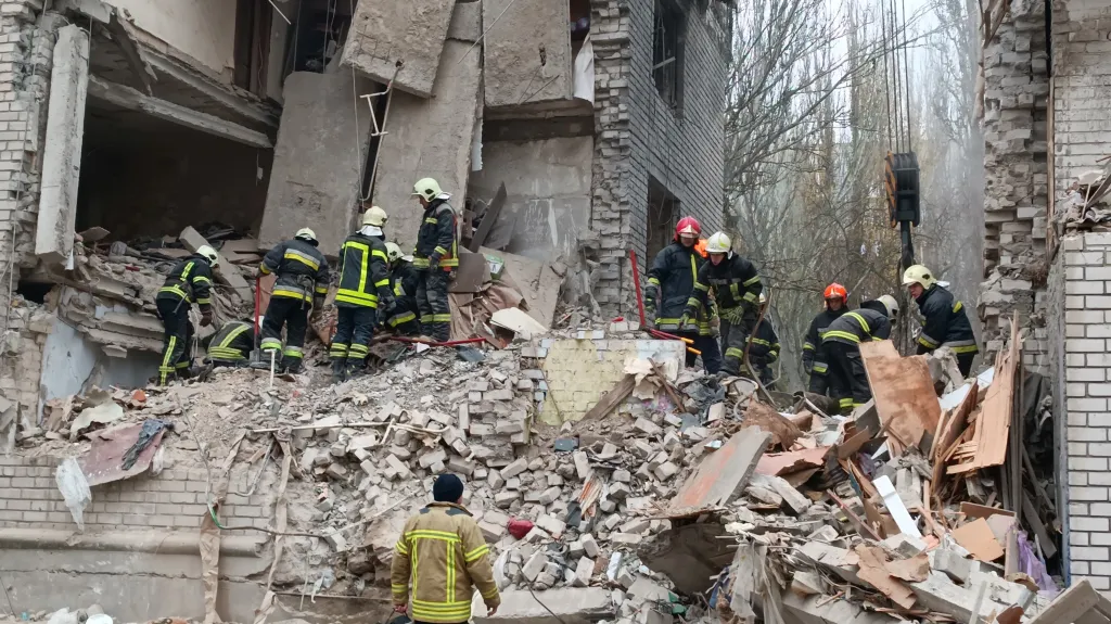 Záchranáři v troskách budovy v Mykolajivu, kterou zničila ruská raketa
