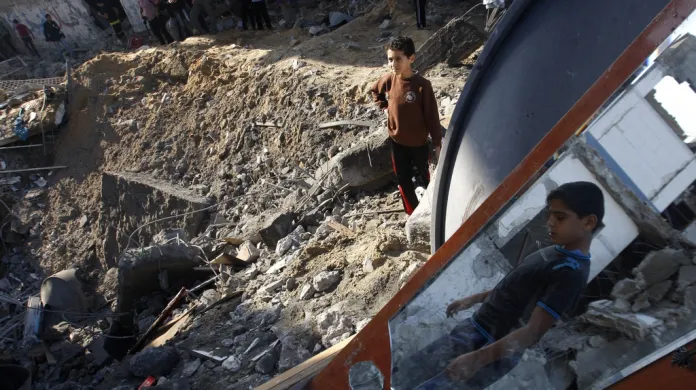 Palestinské děti stojí na troskách domu zničeného izraelskou střelou
