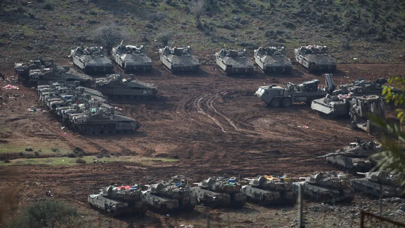 Izraelská vojenská vozidla čekají u silnice poblíž izraelsko-libanonské hranice