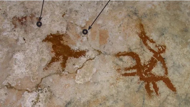 Η εικόνα ενός πουλιού και ενός έφιππου άνδρα, πάνω από το αποτύπωμα της παλάμης  