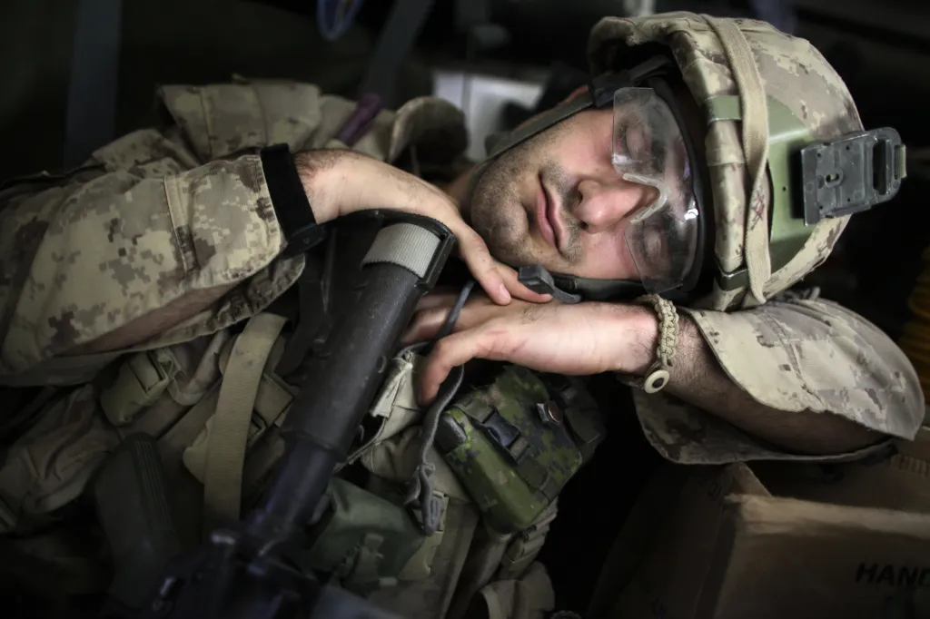 Kanadský voják si dopřává spánek poté, co se zúčastnil pátrání po výbušných zařízeních v Kandaháru, 21. května 2009