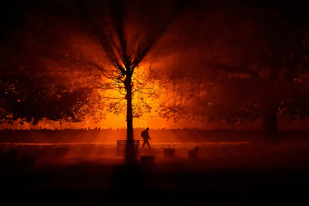Muž s baterkou během chladné mlhavé noci v parku v irském městě Athboy